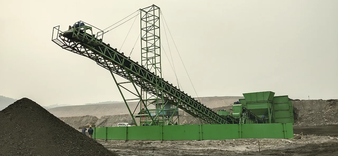 OFN crushing plant and inclined stacking conveyor beside a coal stockpile.